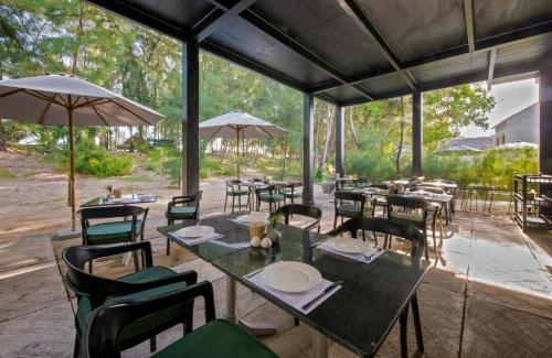 a restaurant with tables and chairs and umbrellas at Sol An Bang Beach Resort & Spa in Hoi An