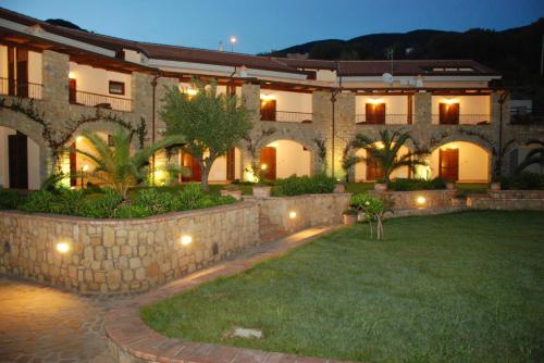 a large house with a stone wall and a yard at Residence Il Casale in Caprioli