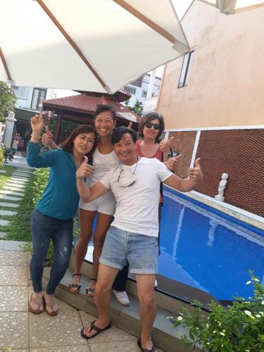 a group of people standing next to a swimming pool at Green Grapefruit Villa in Hoi An