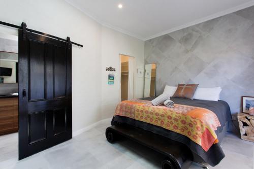 a bedroom with a bed and a black door at Hidden Treasure in Fremantle