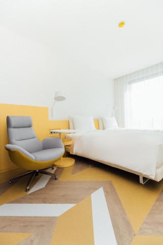 a hotel room with a bed and a chair at The Place Taipei in Taipei