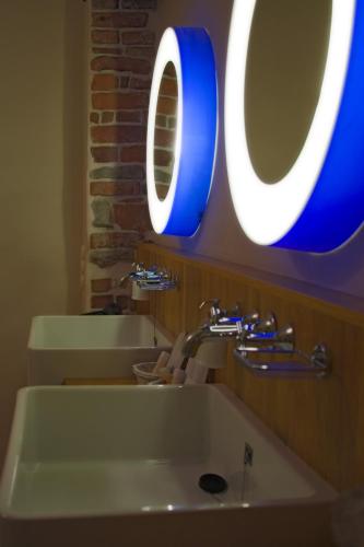a bathroom with a white sink and a blue mirror at St.Olav Hotel in Tallinn