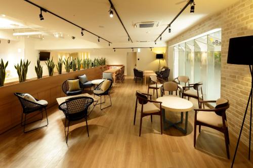 a restaurant with tables and chairs in a room at WeBase TAKAMATSU in Takamatsu