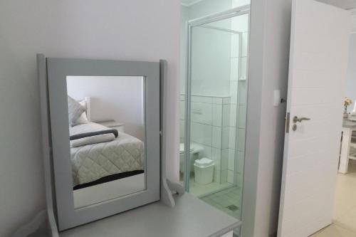 a mirror in a room with a bed and a bathroom at Myoli Holiday Apartments in Sedgefield