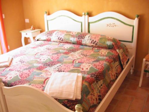 a bedroom with a bed with a quilt on it at B&B Al Cristo in SantʼAmbrogio di Valpolicella
