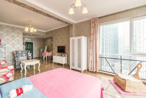 um quarto com uma cama rosa e uma varanda em Xiao Yu B&B Apartment Near Jiefangbei and Hongyadong em Chongqing