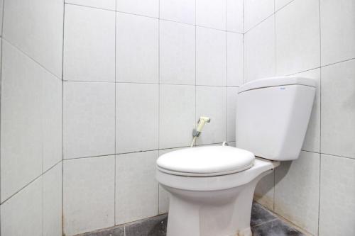 eine weiße Toilette in einem weiß gefliesten Badezimmer in der Unterkunft RedDoorz near RS Sarjito Yogyakarta 2 in Yogyakarta