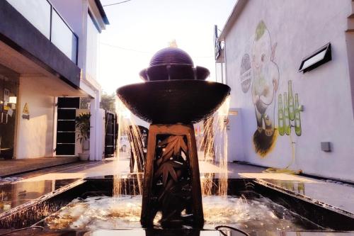 a water fountain in the middle of a building at Beds In Garden Hostel in Ipoh