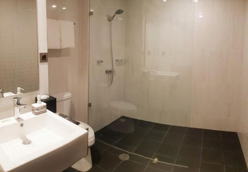 a bathroom with a shower and a sink and a toilet at BW inn Belitung in Tanjungpandan