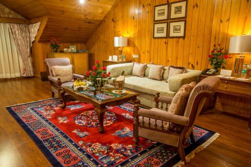 a living room with a couch and a table at The Elgin, Darjeeling - Heritage Resort & Spa in Darjeeling