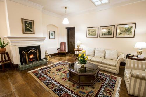 a living room with a couch and a fireplace at The Elgin, Darjeeling - Heritage Resort & Spa in Darjeeling