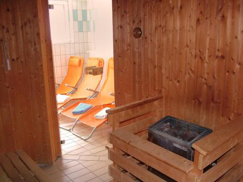 a room with chairs and a room with wooden walls at Strandhotel Achtert Diek in Langeoog