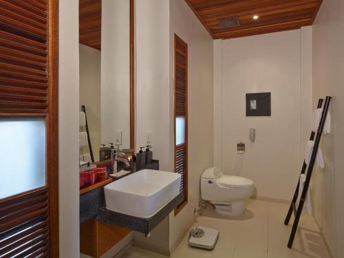 Baño blanco con lavabo y aseo en Villa Villa Pattaya en Nong Prue
