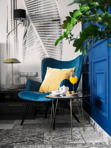 a living room with a blue couch and a table at Aqua Perla Boutique Hotel in Chişinău