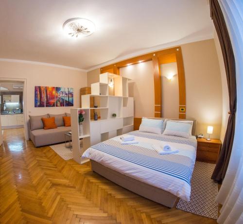 ein Schlafzimmer mit einem großen Bett und einem Sofa in der Unterkunft Buena Vista in Belgrad
