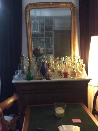 a mirror with a bunch of glass items on a table at La Marquise in Bastia