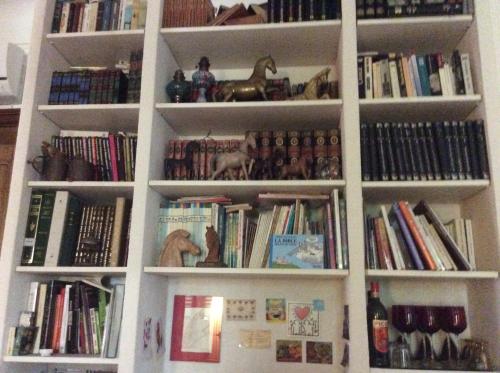 a white book shelf filled with lots of books at La Marquise in Bastia