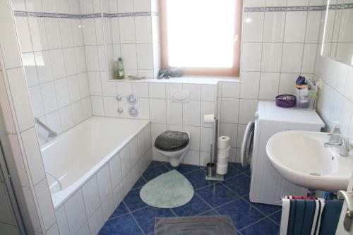 Un baño con bañera, inodoro y lavabo. en Alpen - Apartments II, en Garmisch-Partenkirchen