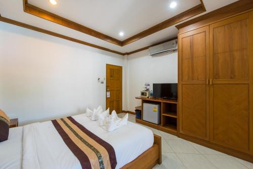 a hotel room with a bed and a tv at Magnific Patong in Patong Beach