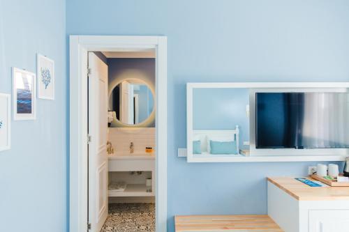 a bathroom with a blue wall with a mirror at Luvi Kaş Otel - Adults Only (+16) in Kaş