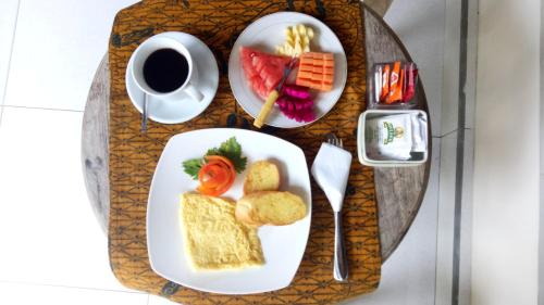 a breakfast tray with food and a cup of coffee at Umah Dajane Guest House in Ubud