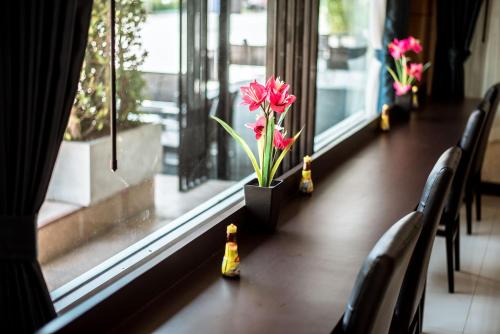 a window with flowers in a vase on a table at Blue Sky Residence Airport in Ban Bang Phli Yai