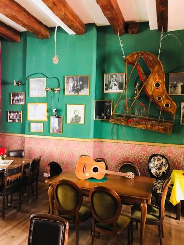 a dining room with green walls and a table and chairs at Willa Sorrento in Szczecin