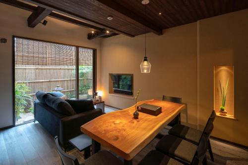 a living room with a wooden table and a couch at Ainotsuji Machiya House in Kanazawa