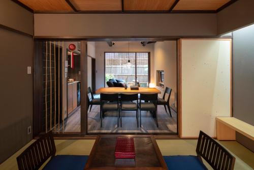 a dining room and living room with a table and chairs at Ainotsuji Machiya House in Kanazawa