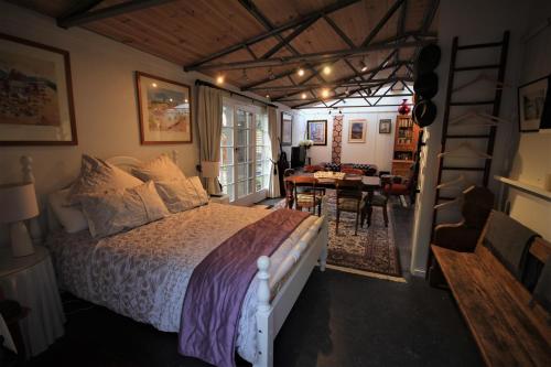 1 dormitorio con 1 cama grande y comedor en Lily's Farm Studio, en Glenlyon