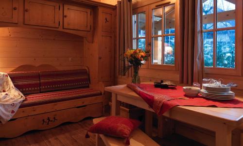 une chambre avec un banc et une table avec des assiettes dans l'établissement Chalets Ile des Barrats, à Chamonix-Mont-Blanc