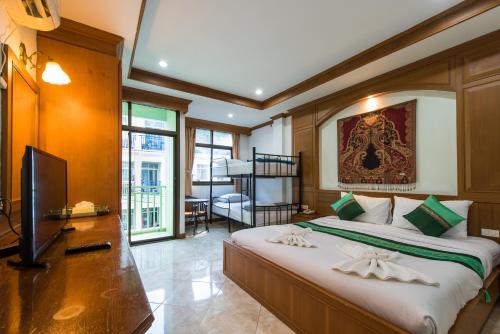 um quarto com uma cama grande e uma televisão em Magnific Guesthouse Patong em Praia de Patong