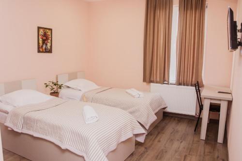 a hotel room with two beds and a window at Red Hotel in Tbilisi City