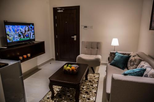 a living room filled with furniture and a tv at Naylover Hotel Suites in Amman