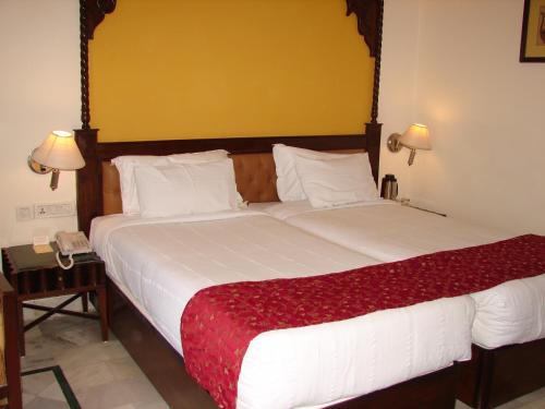 a bedroom with a large bed with a red blanket at Mansingh Palace, Ajmer in Ajmer
