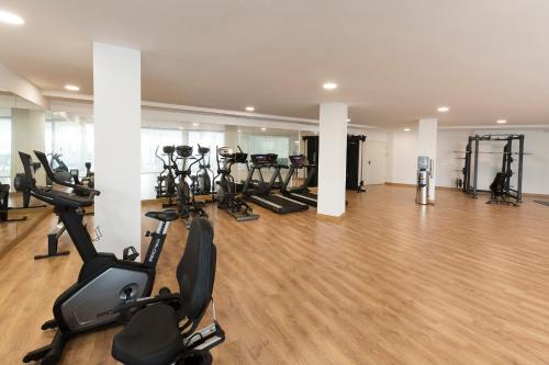 a gym with several treadmills and exercise bikes at Reverence Mare Hotel - Adults Only in Palmanova