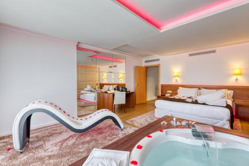 a hotel room with a tub and a bedroom at Senator Marbella in Marbella