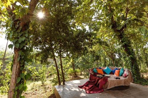 a couch sitting on a table under a tree at SaffronStays Masaya, Alibaug - pet-friendly villa with alfresco dining in Alibaug