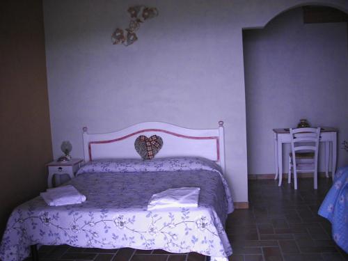 a bedroom with a bed and a table with a chair at B&B Al Cristo in SantʼAmbrogio di Valpolicella