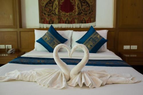 two swans making a heart shape on a bed at Magnific Patong in Patong Beach