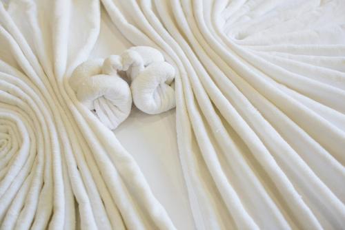 two towels laying on top of a white blanket at Magnific Patong in Patong Beach