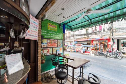 a table and chairs in front of a store at Magnific Patong in Patong Beach