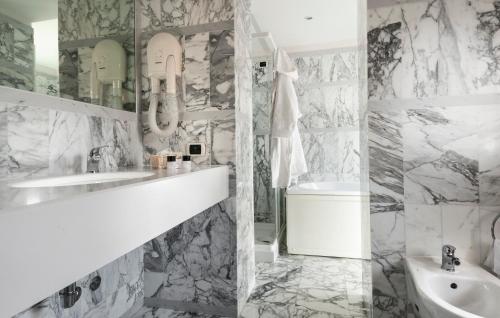 a white bathroom with a sink and a toilet at Hotel Vittoria in Faenza
