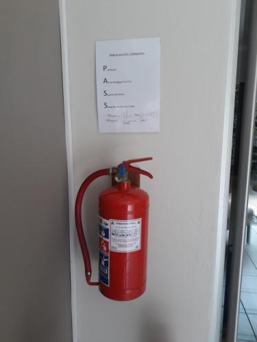 a red fire hydrant is hanging in a wall at Fin and Feather Guest Lodge in Boksburg