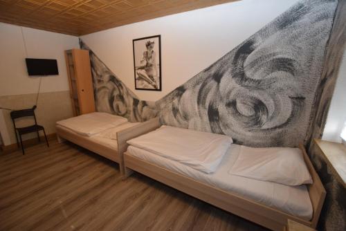 2 letti in una camera con un murale di Stuttgart Bad Cannstatt a Stoccarda