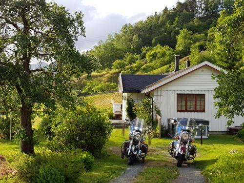duas motos estacionadas em frente a uma casa em Dalhus - House in the Valley em Norddal