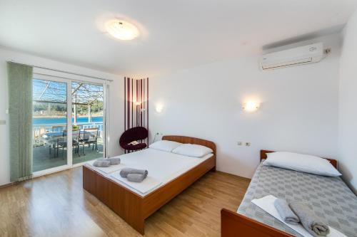a bedroom with two beds and a balcony at Apartments Barbir in Ploče