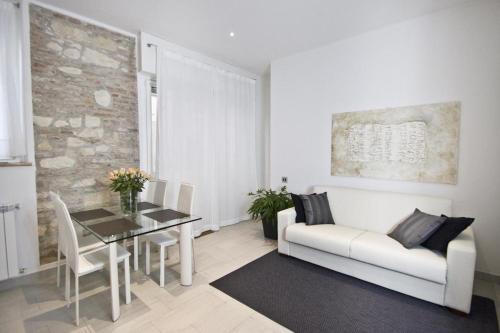 ein Wohnzimmer mit einem weißen Sofa und einem Tisch in der Unterkunft Cortiletto in Verona