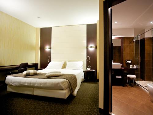 ステッツァーノにあるメルキュール ベルガモ アエロポルトのベッドとバスルーム付きのホテルルームです。