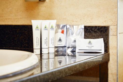 um balcão de casa de banho com produtos de higiene pessoal numa mesa em First Group The Palace All-Suite em Durban